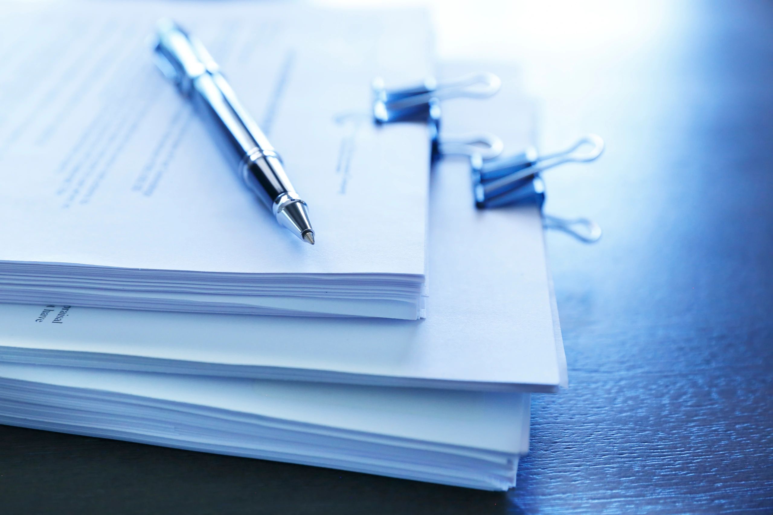 Pen resting on legal documents